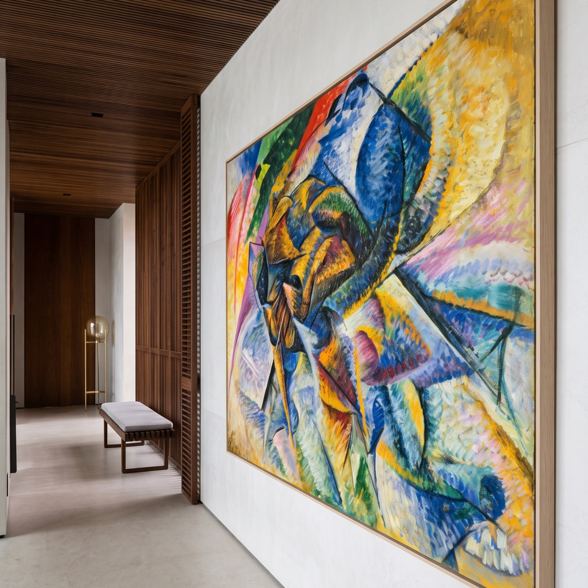 Dynamism of a Cyclist by Umberto Boccioni — large blue and yellow Futurist canvas art on a hallway wall